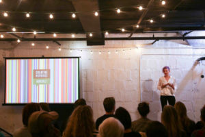 Cassie Barrett on stage giving a talk at Creative Mornings.