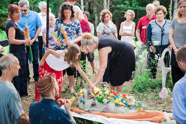 Kathy-188-1065 Woman and young girl placing flowers on Kathy's shrouded body.